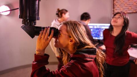 Astrophysics Minor students looks through telescope